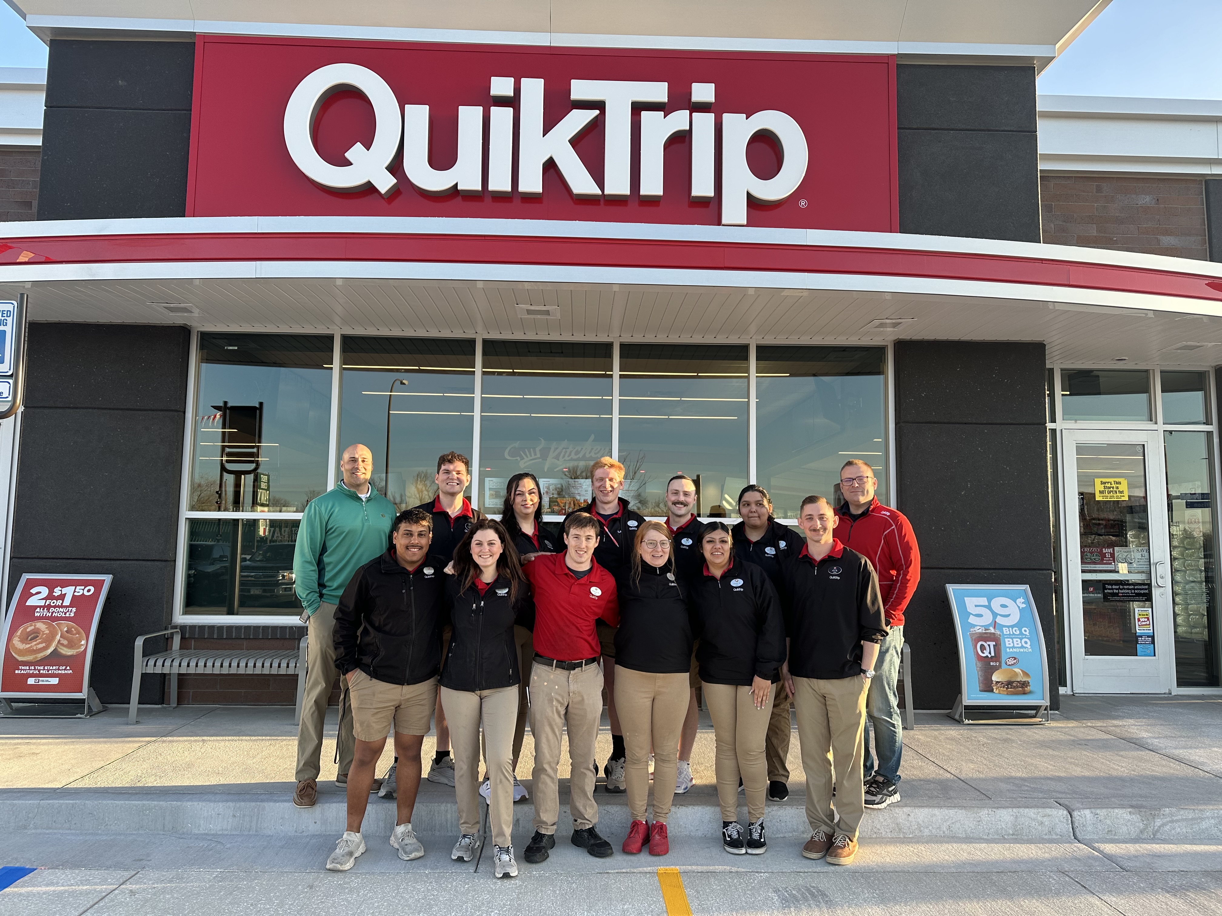 Store employees pose on April 11, 2024, outside QuikTrip’s new location in Lakewood, Colo.